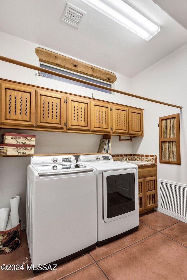 laundry room with washing machine and dryer, tile patterned flooring, cabinet space, and visible vents