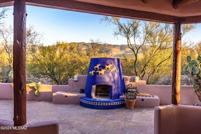 view of patio featuring an outdoor fireplace and a mountain view