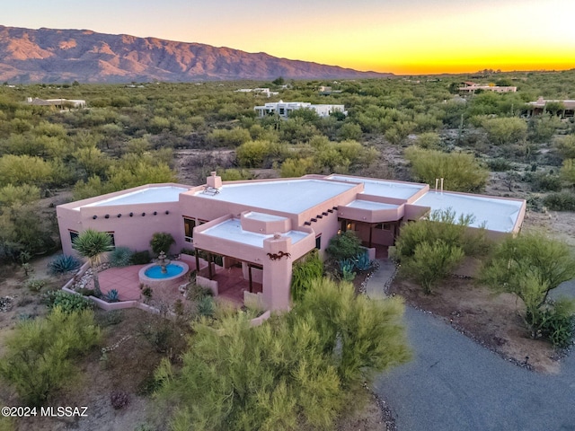 aerial view at dusk featuring a mountain view