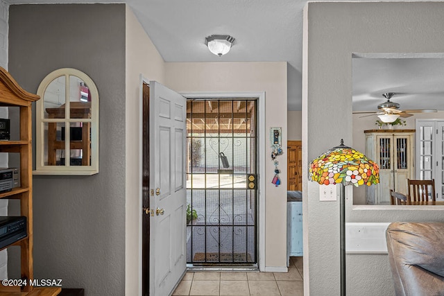 foyer entrance with light tile patterned flooring and ceiling fan