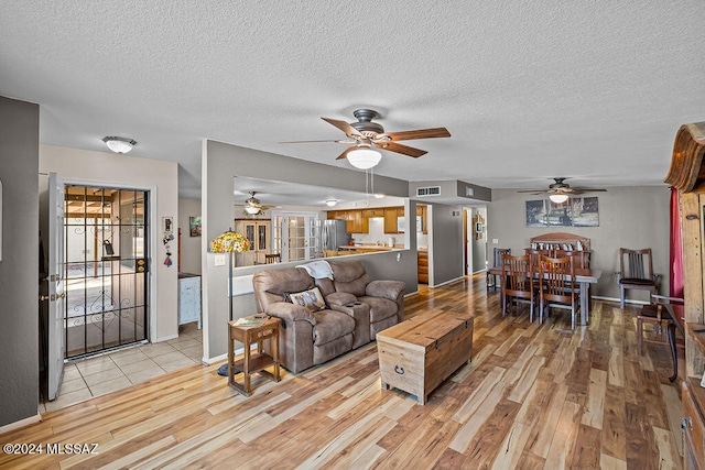 living room featuring light hardwood / wood-style flooring and a textured ceiling