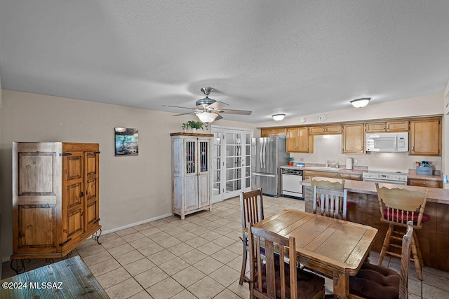 dining area featuring ceiling fan, a textured ceiling, sink, and light tile patterned floors