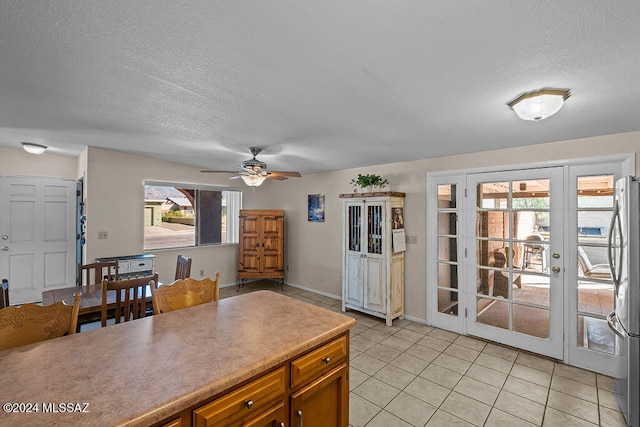 kitchen featuring a textured ceiling, stainless steel fridge, light tile patterned flooring, and ceiling fan