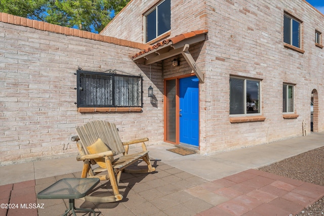 view of exterior entry featuring a patio area