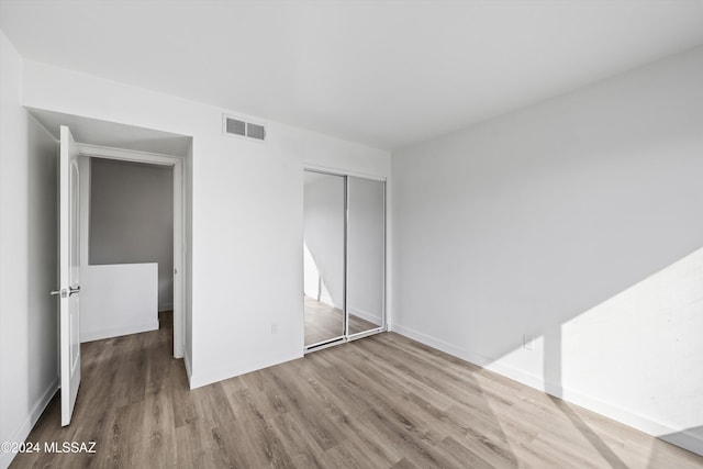 unfurnished bedroom featuring wood-type flooring and a closet