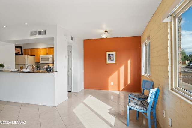 kitchen with light tile patterned floors and white appliances