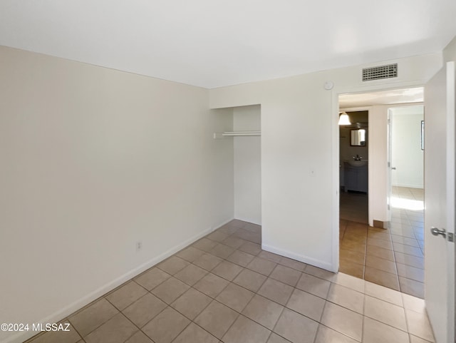 unfurnished bedroom with a closet and light tile patterned floors