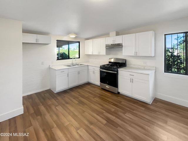 kitchen with sink, stainless steel gas stove, white cabinets, and dark hardwood / wood-style flooring