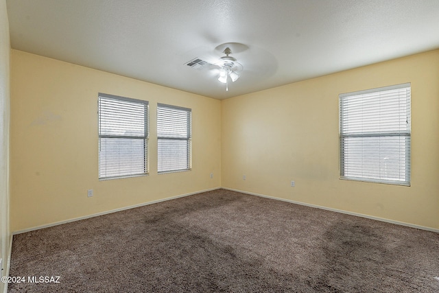 unfurnished room with ceiling fan and carpet