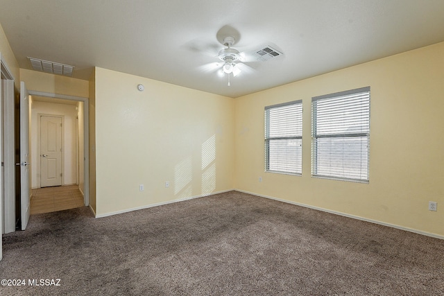 spare room with ceiling fan and carpet