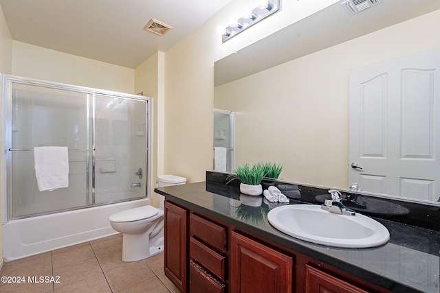 full bathroom featuring vanity, enclosed tub / shower combo, toilet, and tile patterned floors