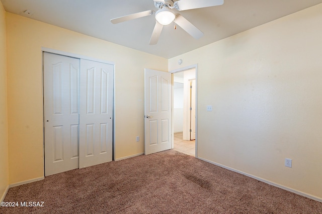 unfurnished bedroom with a closet, light carpet, and ceiling fan