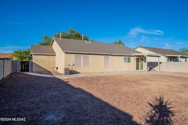 back of property with central air condition unit and a patio area