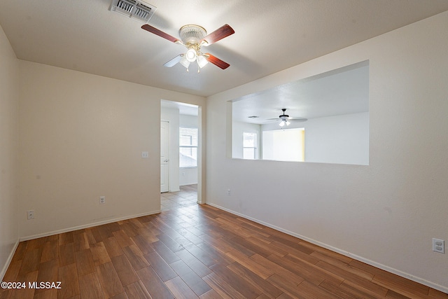 spare room with dark wood-type flooring and ceiling fan