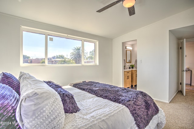 carpeted bedroom with ensuite bathroom and ceiling fan