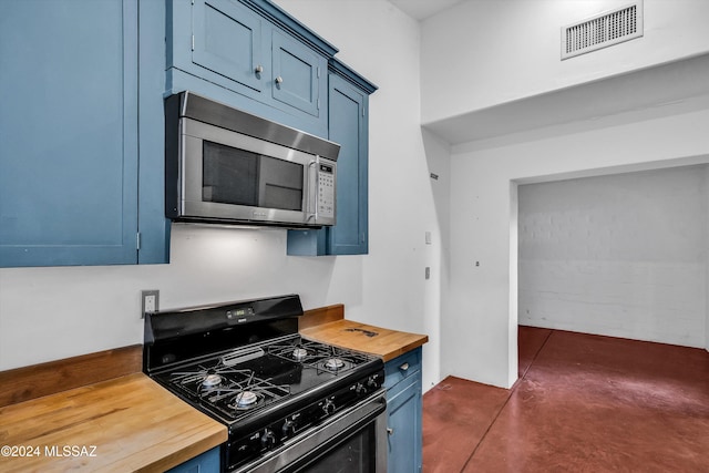 kitchen with blue cabinetry, black gas stove, and butcher block countertops