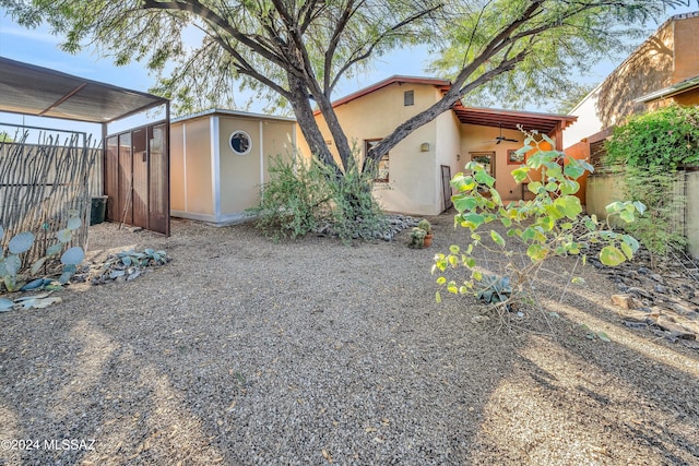 exterior space with ceiling fan and a shed