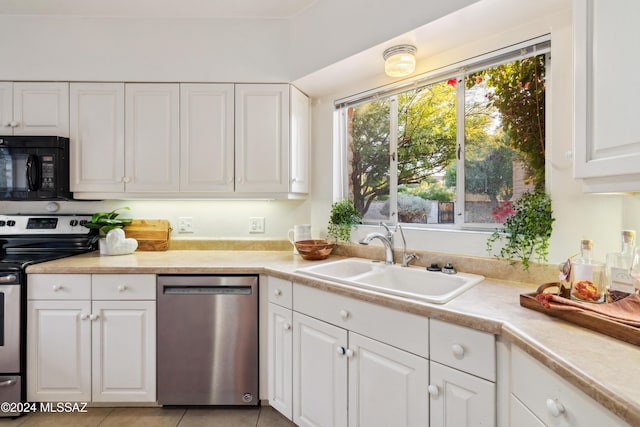 kitchen featuring light tile patterned flooring, appliances with stainless steel finishes, white cabinetry, and sink