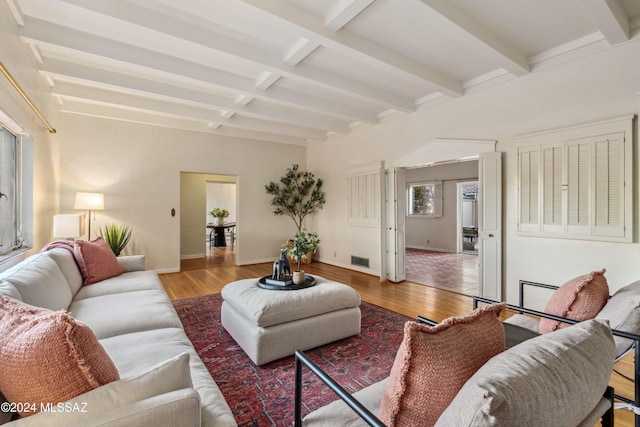 living room with beam ceiling and light wood-type flooring