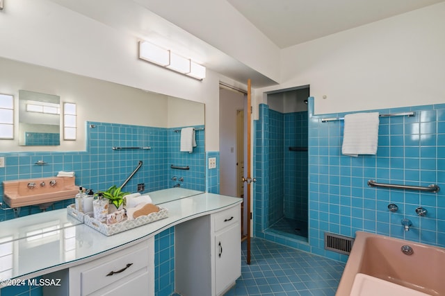 bathroom with shower with separate bathtub, vanity, tile patterned floors, and tile walls