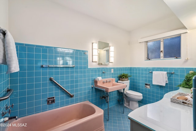 bathroom with tile patterned floors, a washtub, sink, tile walls, and toilet