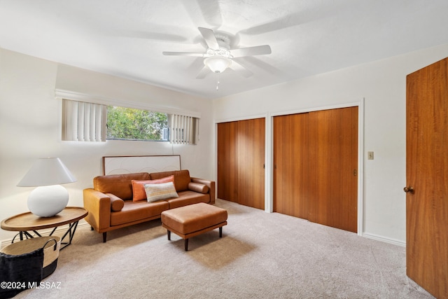 sitting room with ceiling fan and light colored carpet