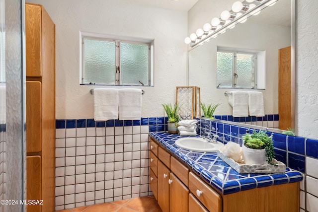 bathroom with tile patterned floors, vanity, and tile walls