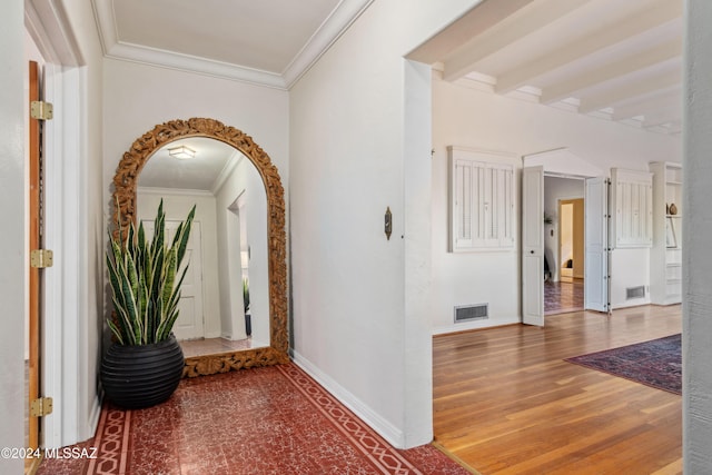 hallway with beamed ceiling, hardwood / wood-style floors, and crown molding