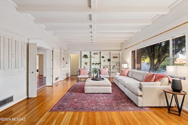 living room featuring beamed ceiling and wood-type flooring