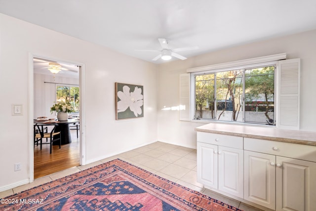 interior space with ceiling fan, a healthy amount of sunlight, and light tile patterned floors