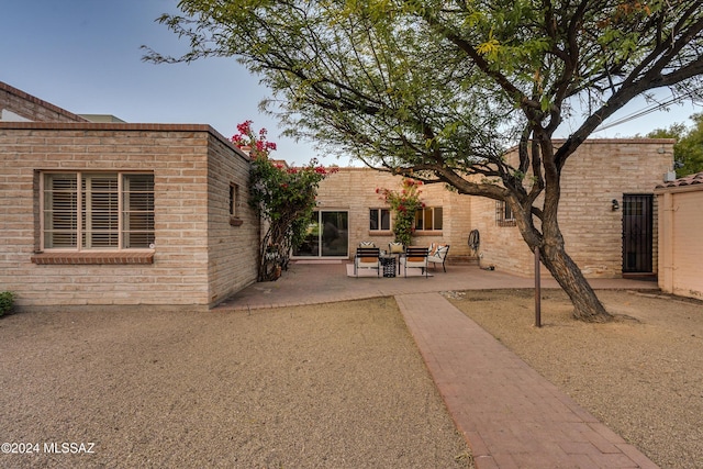 back of property featuring a patio area and an outdoor hangout area