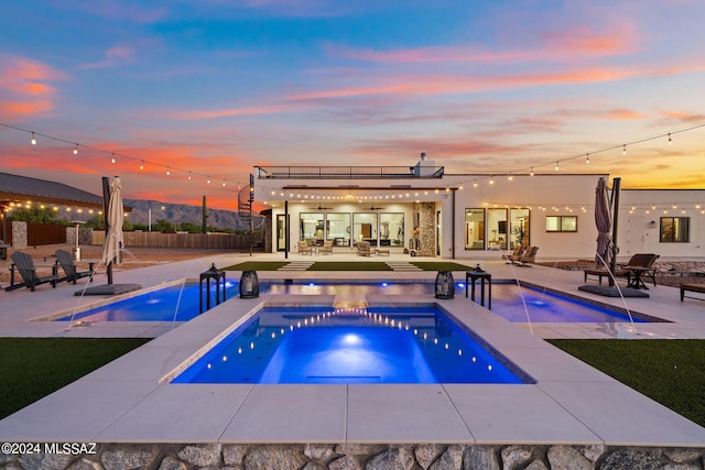 view of pool with a patio, a mountain view, fence, a fenced in pool, and a hot tub