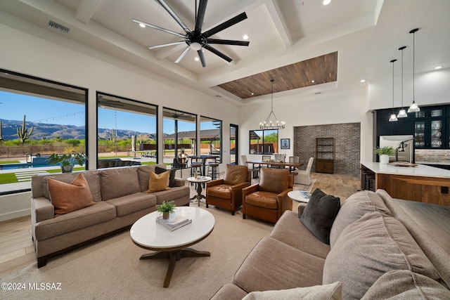 living room featuring light wood-type flooring, an inviting chandelier, visible vents, and a mountain view