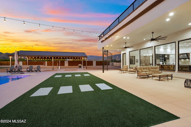 exterior space featuring ceiling fan, fence, an outdoor living space, and a fenced in pool