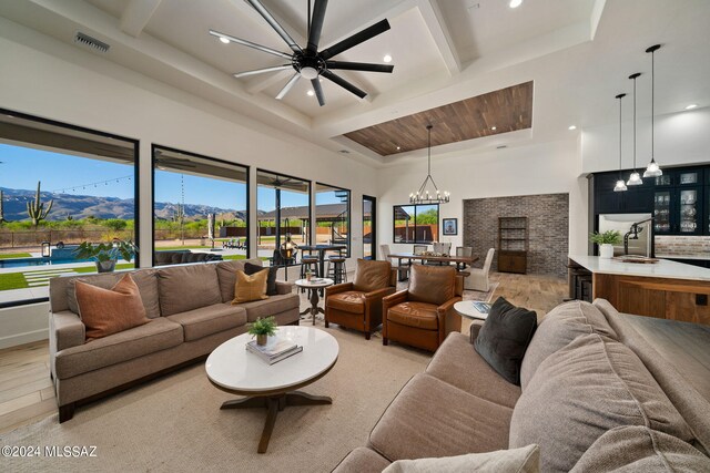 living room featuring light wood-type flooring, an inviting chandelier, visible vents, and a mountain view