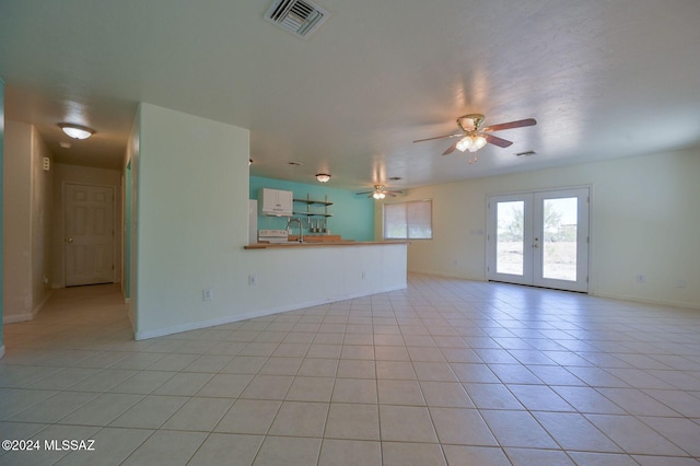 unfurnished living room with french doors, ceiling fan, and light tile patterned flooring