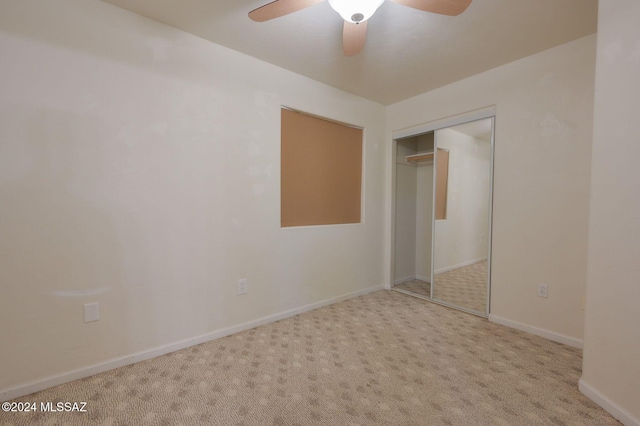 unfurnished bedroom featuring ceiling fan, a closet, and light colored carpet