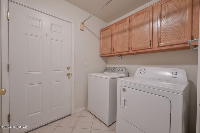 washroom featuring cabinets, light tile patterned flooring, and separate washer and dryer