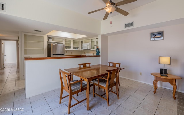 dining space featuring visible vents, a ceiling fan, and light tile patterned flooring