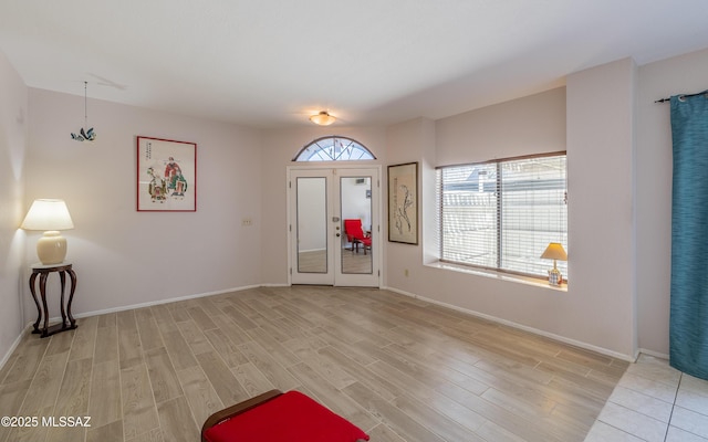 foyer featuring light wood-style flooring and baseboards