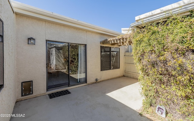 property entrance featuring a patio area and stucco siding