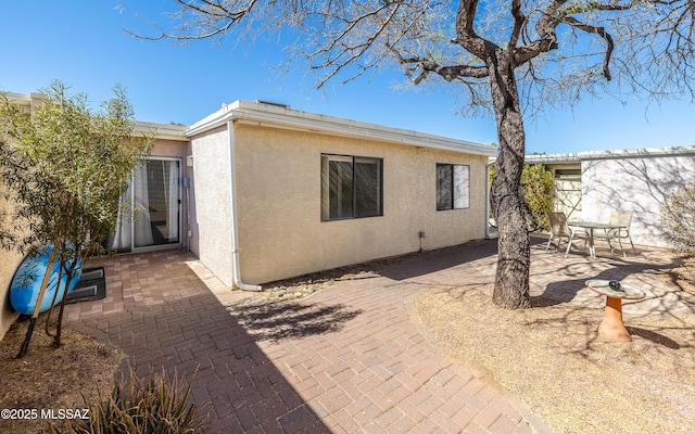back of property featuring a patio and stucco siding