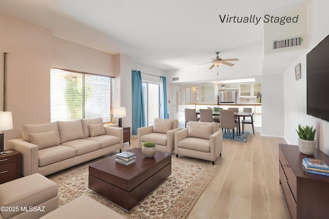living area with visible vents, light wood-style flooring, and ceiling fan