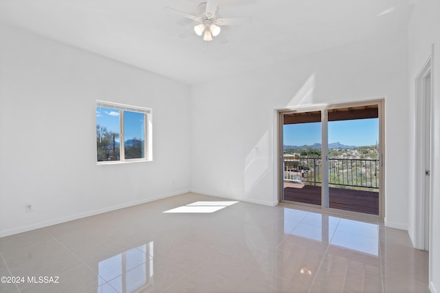 unfurnished living room featuring ceiling fan and light tile patterned floors