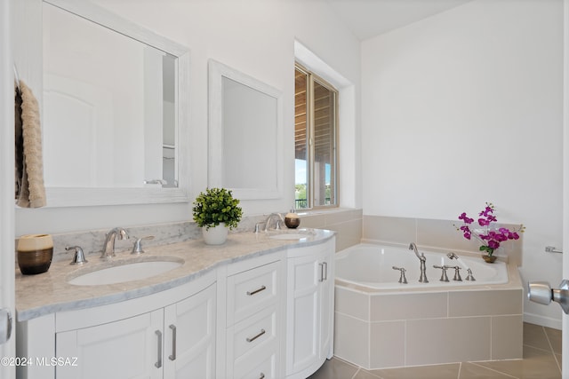 bathroom featuring tiled bath, tile patterned flooring, and vanity