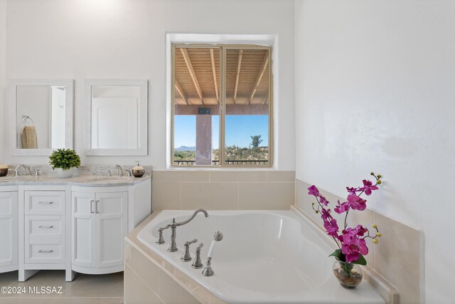 bathroom featuring vanity, tiled bath, and tile patterned floors