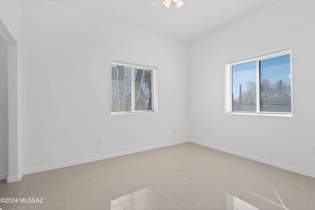 empty room featuring ceiling fan and light tile patterned flooring