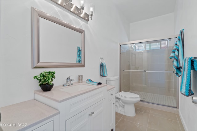 bathroom featuring tile patterned flooring, vanity, toilet, and a shower with door