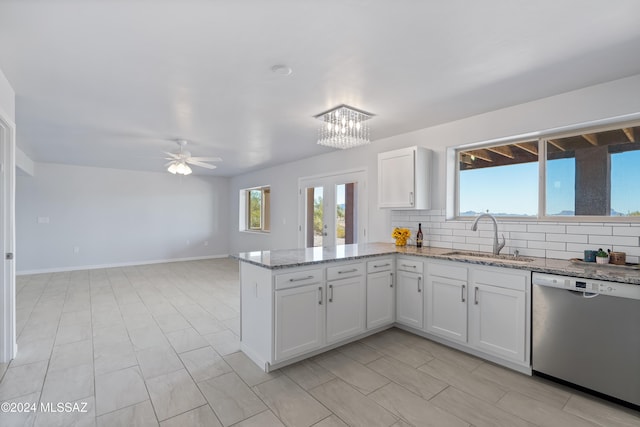 kitchen with light stone counters, dishwasher, sink, tasteful backsplash, and white cabinetry