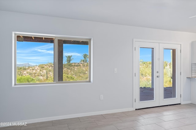 unfurnished room with french doors and light tile patterned floors